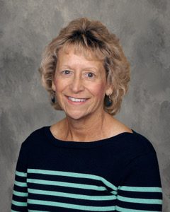 A woman with blonde hair and blue striped shirt.